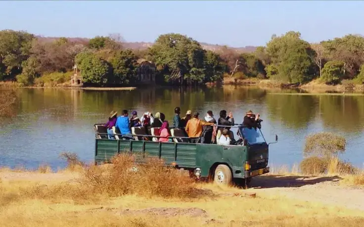 Tourists on a Canter Safari watching a waterhole in Ranthambore National Park with Namaste Yatra Tours